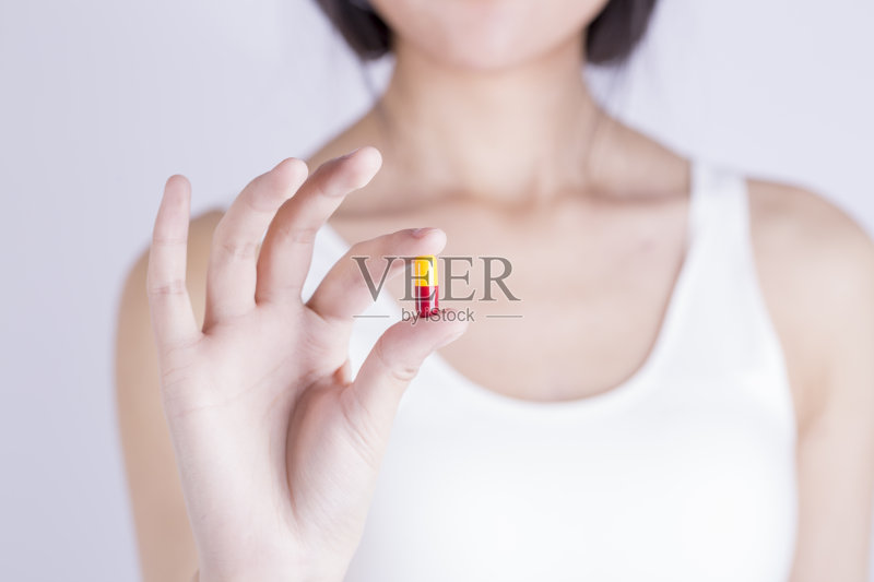 手里拿着黄色胶囊丸正版图片素材
