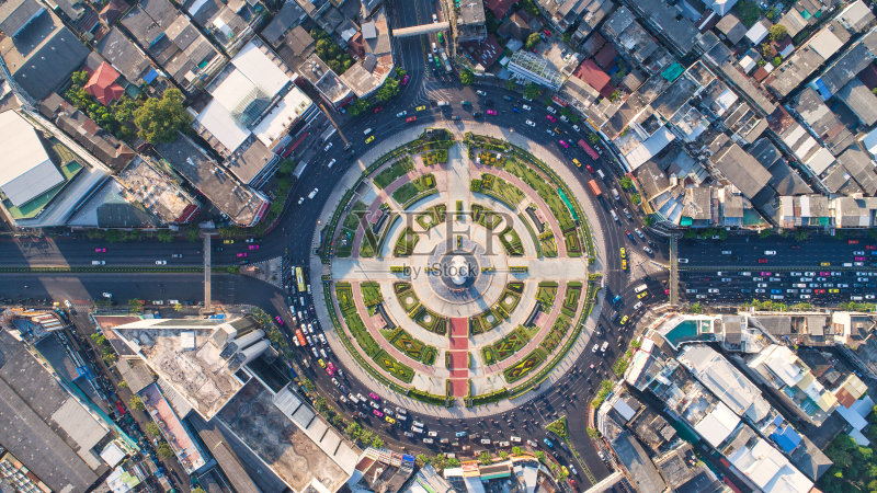 鸟瞰图,道路环岛,高速公路与汽车停车场在泰国的城市。美丽的街道,市中心,城市景观,顶视图。背景正版图片素材