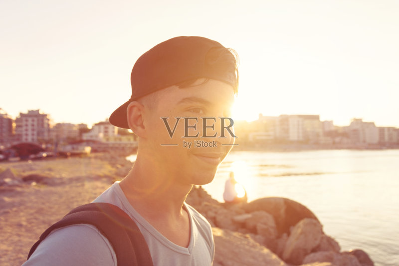 夕阳下戴着帽子的快乐潮男正版图片素材