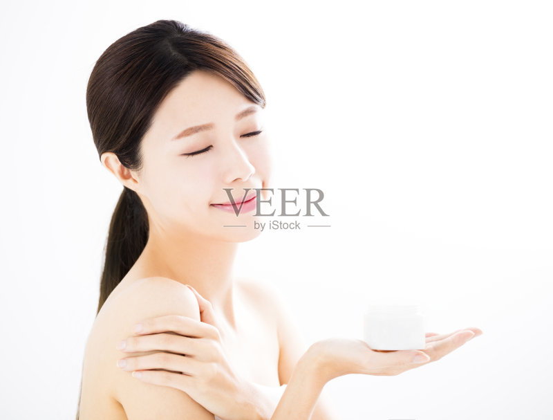 美丽的年轻女子展示美容产品在手正版图片素材