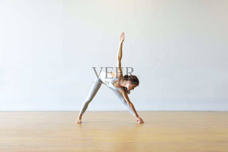 年轻女子在白色地板上做瑜伽/普拉提。正版图片素材