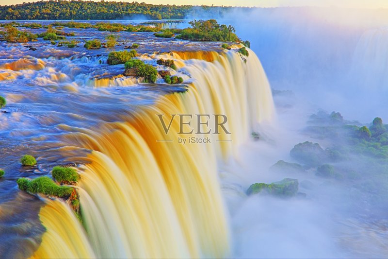 令人印象深刻的伊瓜苏瀑布景观,从长期暴露在戏剧性的日落模糊的运动-田园般的魔鬼的喉咙-巴西的Foz do Iguacu,巴拉那,阿根廷的伊瓜苏港,米塞内斯和巴拉圭-南美正版图片素材