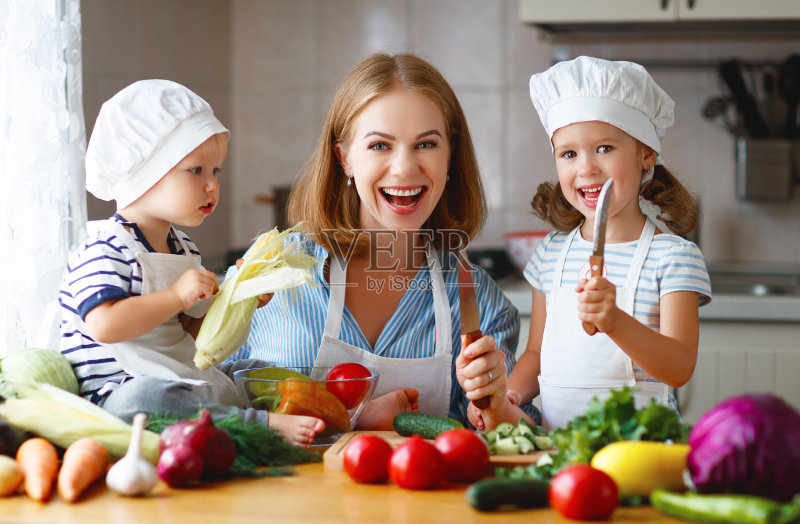 健康饮食。快乐的家庭妈妈和孩子们准备蔬菜沙拉正版图片素材