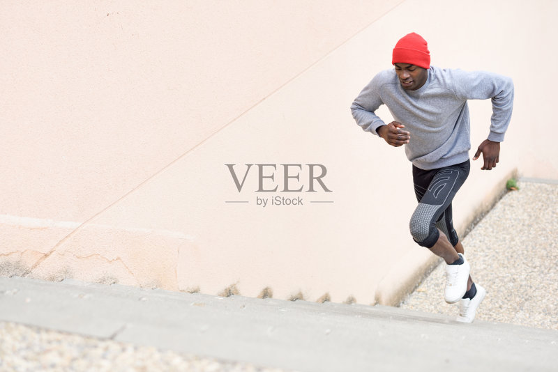 一个黑人在室外奔跑,背景是城市正版图片素材