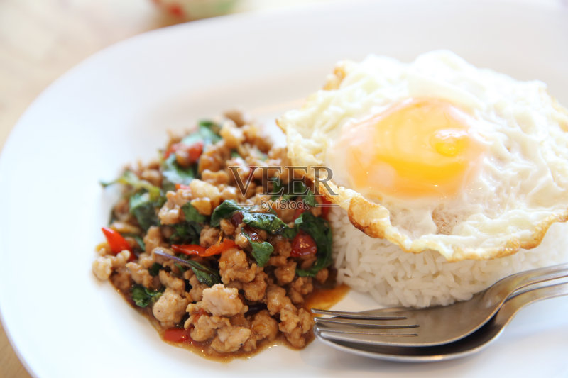 炒猪肉和罗勒与米饭和鸡蛋木背景泰国食物正版图片素材