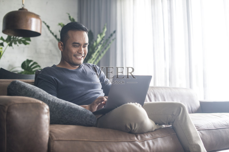 年轻的亚洲男人在家工作。正版图片素材