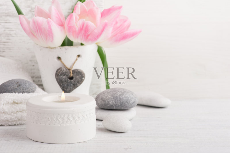 粉红色的郁金香,鹅卵石和点燃的蜡烛正版图片素材