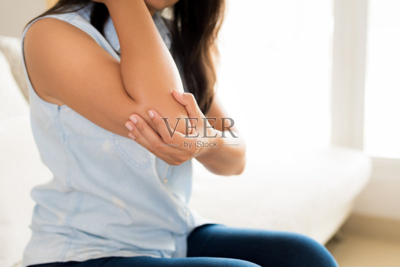 近距离观察肘部受伤疼痛的妇女。保健和手臂疼痛概念。正版图片素材