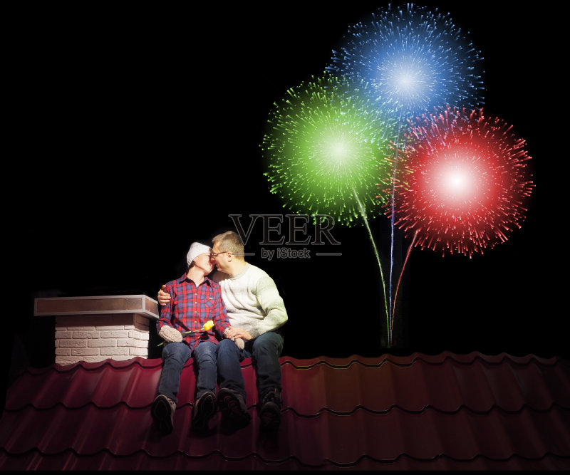 一对夫妇晚上坐在房子的屋顶上。正版图片素材