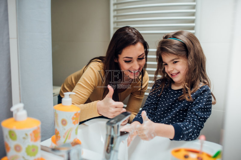 一名妇女在帮女儿洗手正版图片素材