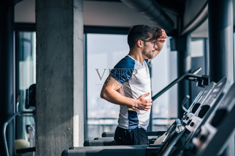 在一个阳光明媚的日子在跑步机上跑步。正版图片素材