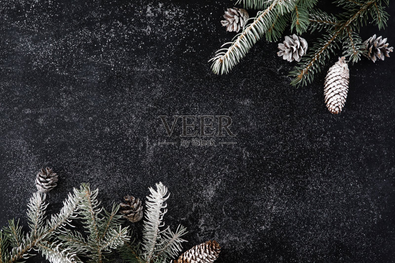 圣诞节的黑色背景与雪冷杉树和松果。顶部视图与复制空间正版图片素材