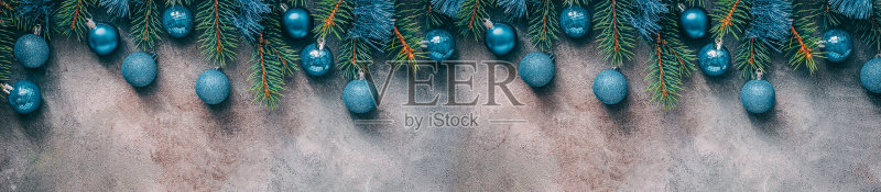 美丽的圣诞节边界,冷杉树枝装饰蓝色球和金属箔在一个黑色纹理的乡村背景。俯视图,平放,复制空间。正版图片素材