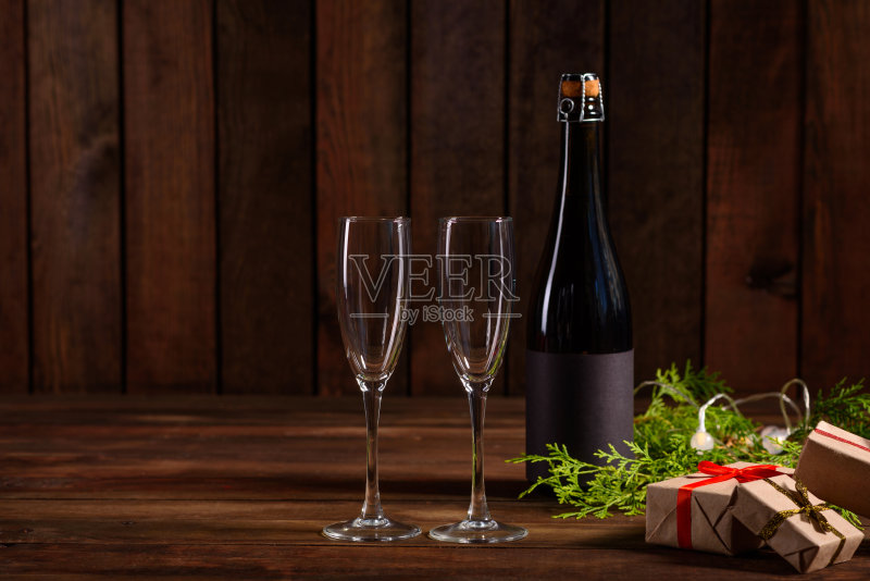 圣诞假期餐桌上放着玻璃杯和一瓶香槟正版图片素材