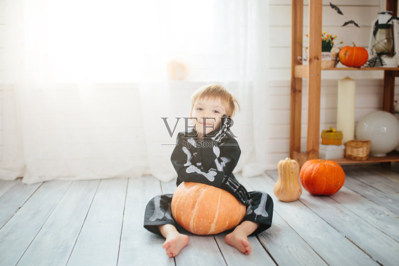 一个穿着骷髅装的小男孩准备庆祝万圣节。万圣节化妆室里的男孩。正版图片素材