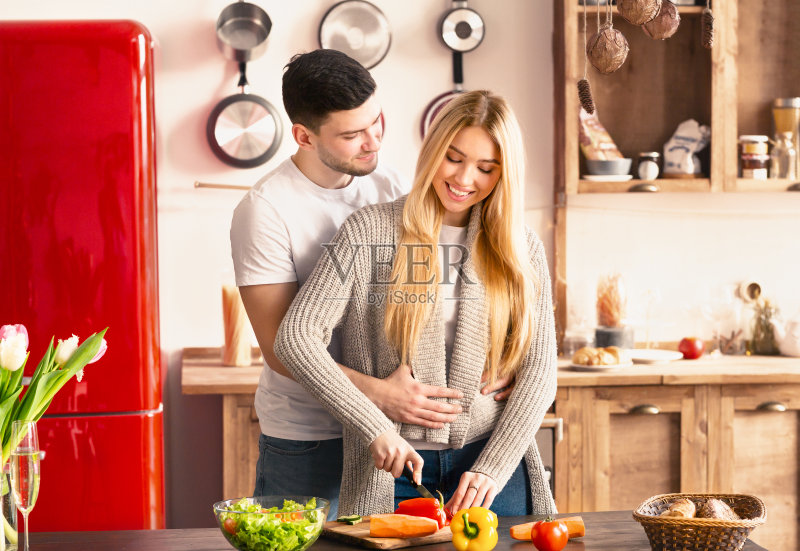 新婚夫妇拥抱在一起做饭照片摄影图片