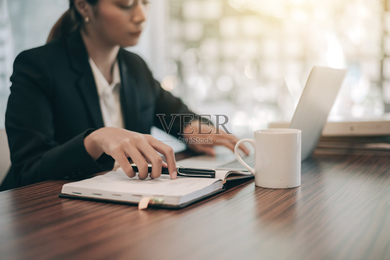近距离的手。女商人用笔记本电脑处理财务报告。正版图片素材