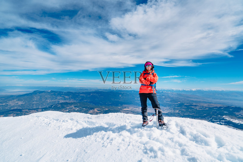 自信的老年高山登山者双臂交叉站在高海拔的山峰在冬天正版图片素材