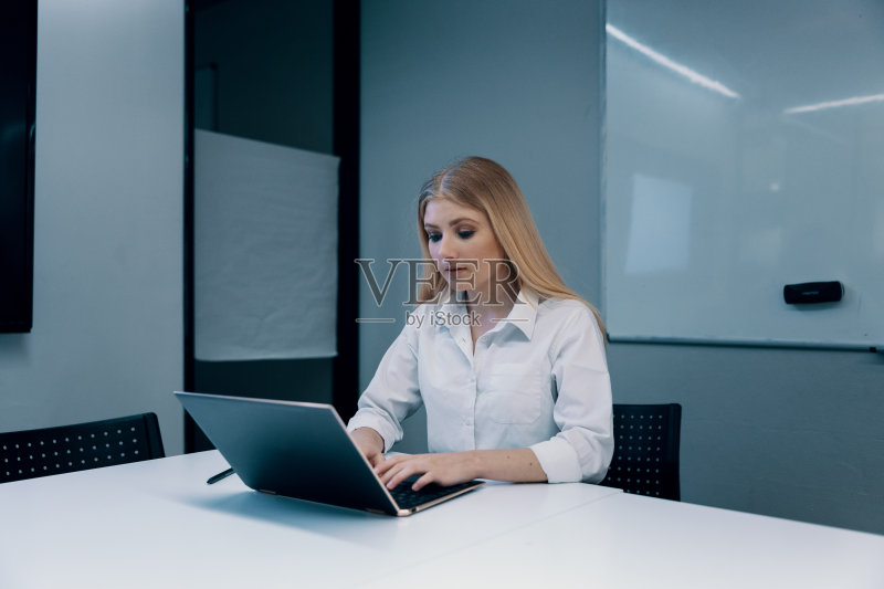 在办公室里用笔记本电脑和平板电脑工作的女商人正版图片素材