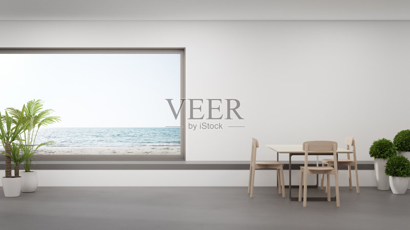 餐桌在现代海滩别墅或豪华酒店的起居区和座位附近的大餐厅混凝土地板上。正版图片素材