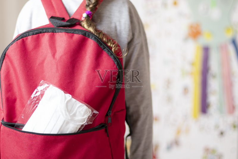 这个小女孩的书包里有一个保护面罩。正版图片素材