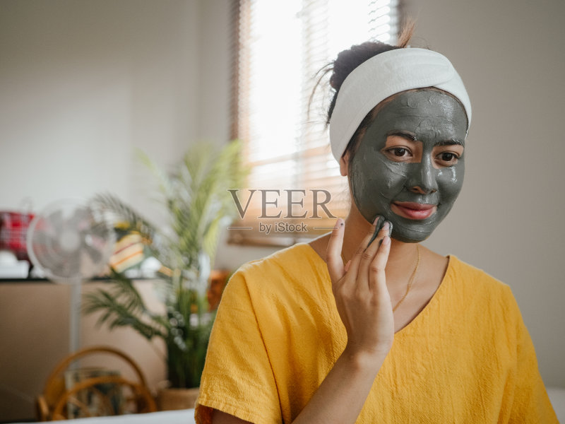 年轻女子在脸上敷面膜。正版图片素材