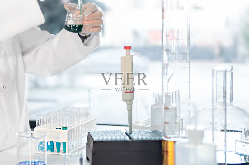 难以辨认的实验室技术员向试管中注入蓝色液体正版图片素材