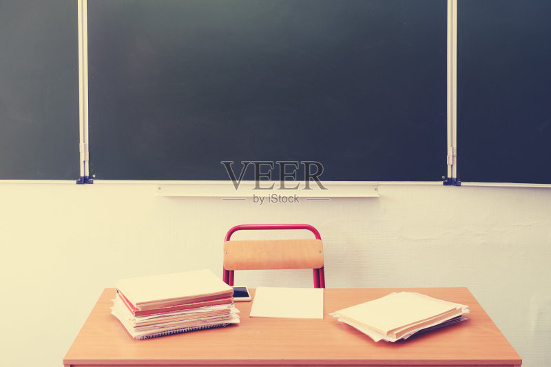空荡荡的学校桌子上没有人。老师的课桌靠黑板,没有人正版图片素材