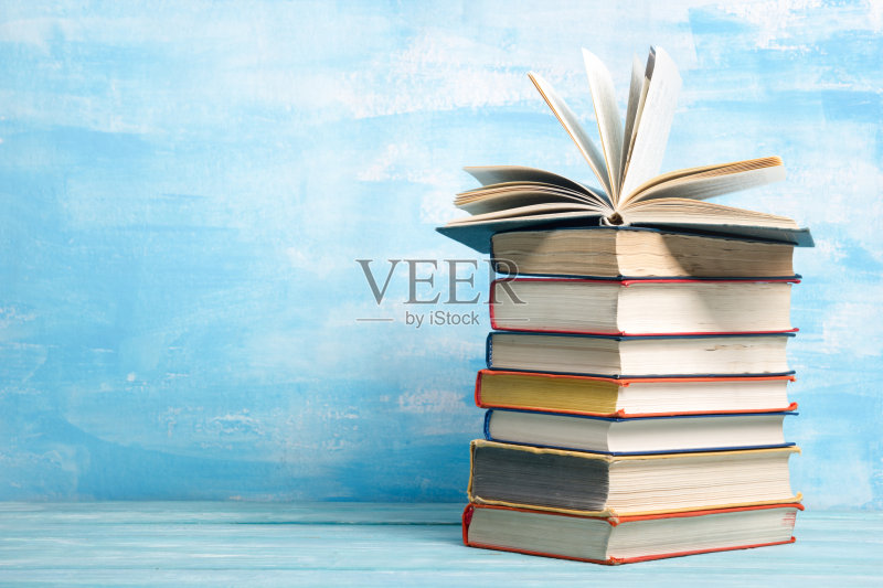 组成与古老的精装书,日记,扇页木制甲板桌子和抽象的背景。书堆积。回到学校。副本的空间。教育蓝色背景。正版图片素材