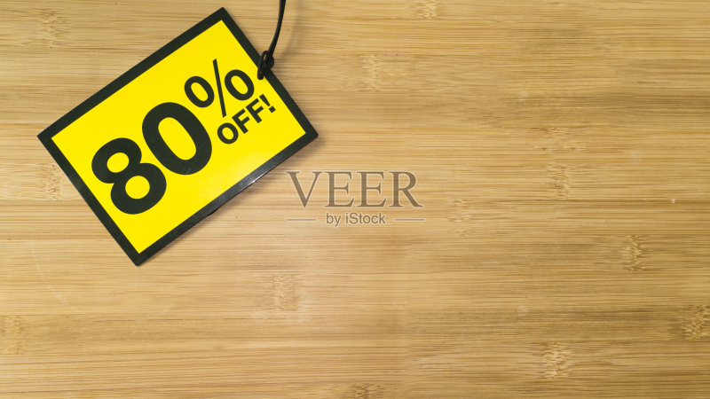 木制背景上的黄色销售标签。黑色星期五销售正版图片素材