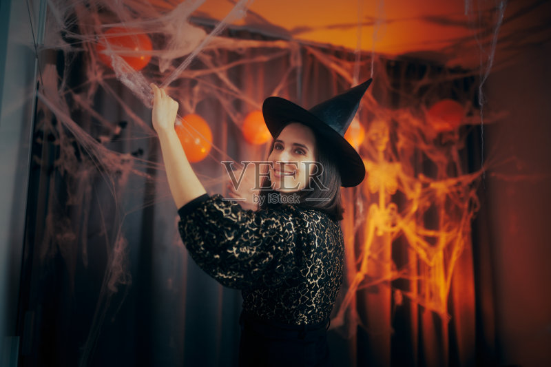 快乐的女人为万圣节装饰她的家正版图片素材