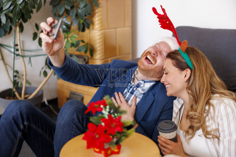 商务人士在办公室用智能手机进行视频通话并庆祝圣诞节照片摄影图片
