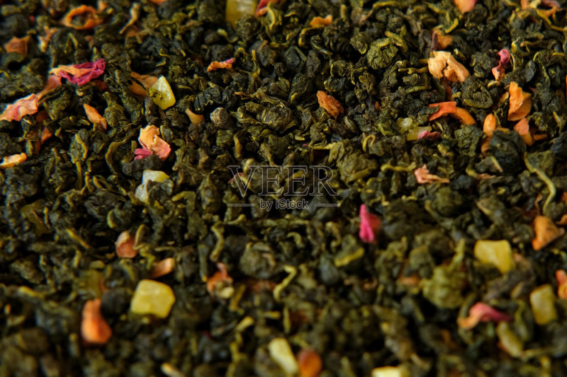 散叶芒果菠萝水果茶壁纸。混合黑绿干茶叶,特写,宏观,俯视,纹理,干燥的茶叶旋转,抽象食品饮料背景,全画幅照片摄影图片