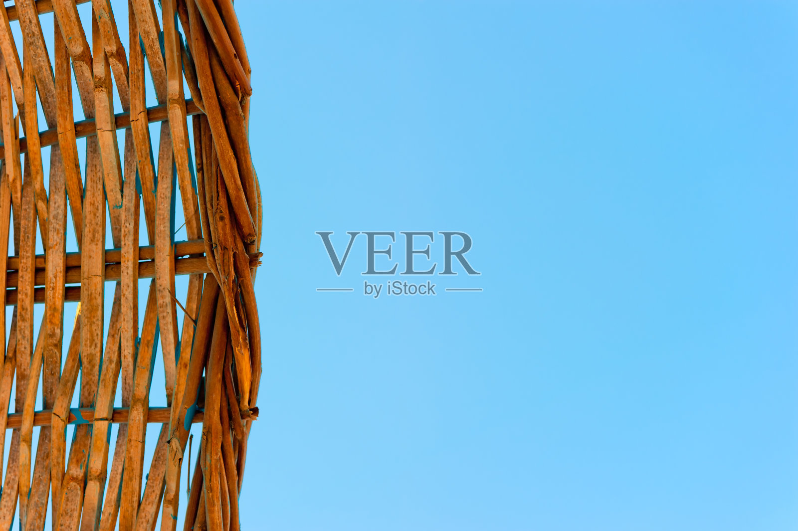 稻草编织的沙滩伞在晴朗的蓝天照片摄影图片