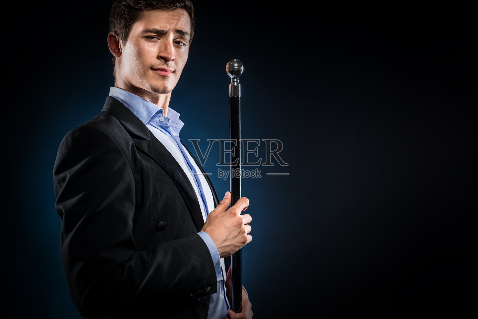 穿着优雅的黑色夹克，拄着手杖的男人照片摄影图片