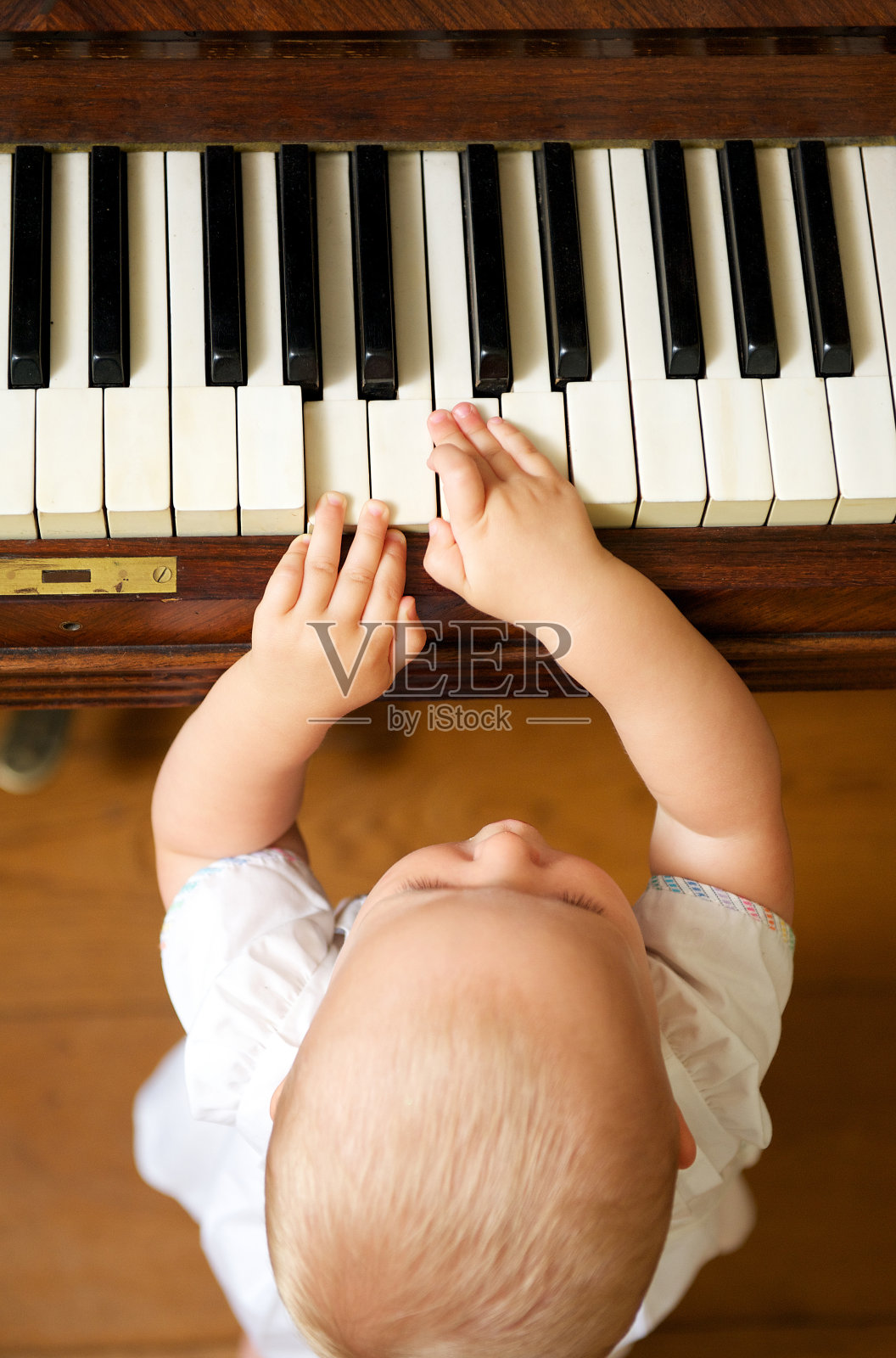 一个可爱的婴儿在弹钢琴照片摄影图片