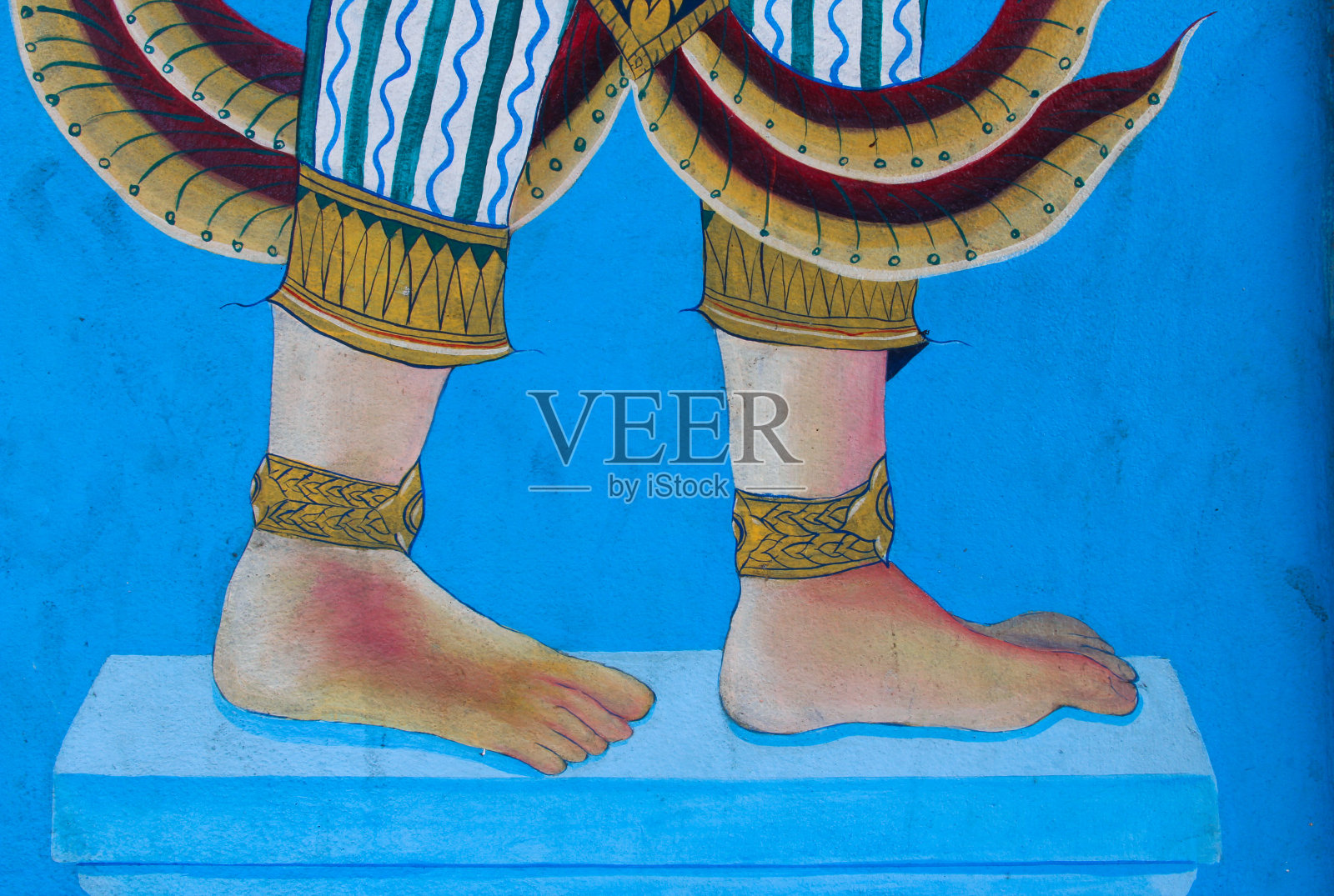 蓝色的墙上画着带脚链的赤脚画照片摄影图片