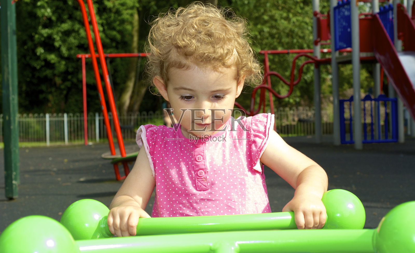 小女孩在公园里玩跷跷板照片摄影图片