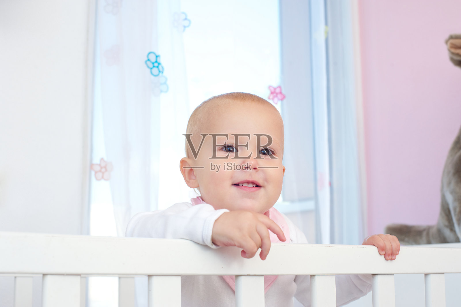 横向肖像的一个可爱的婴儿微笑在婴儿床照片摄影图片