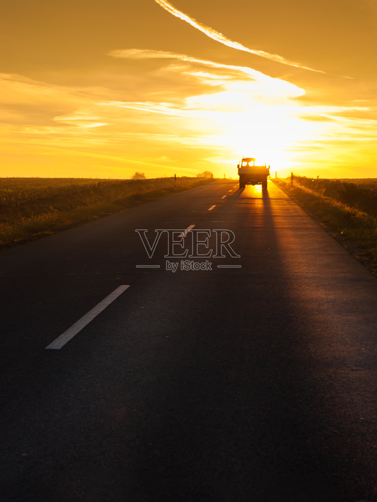 卡车在夕阳下行驶。照片摄影图片