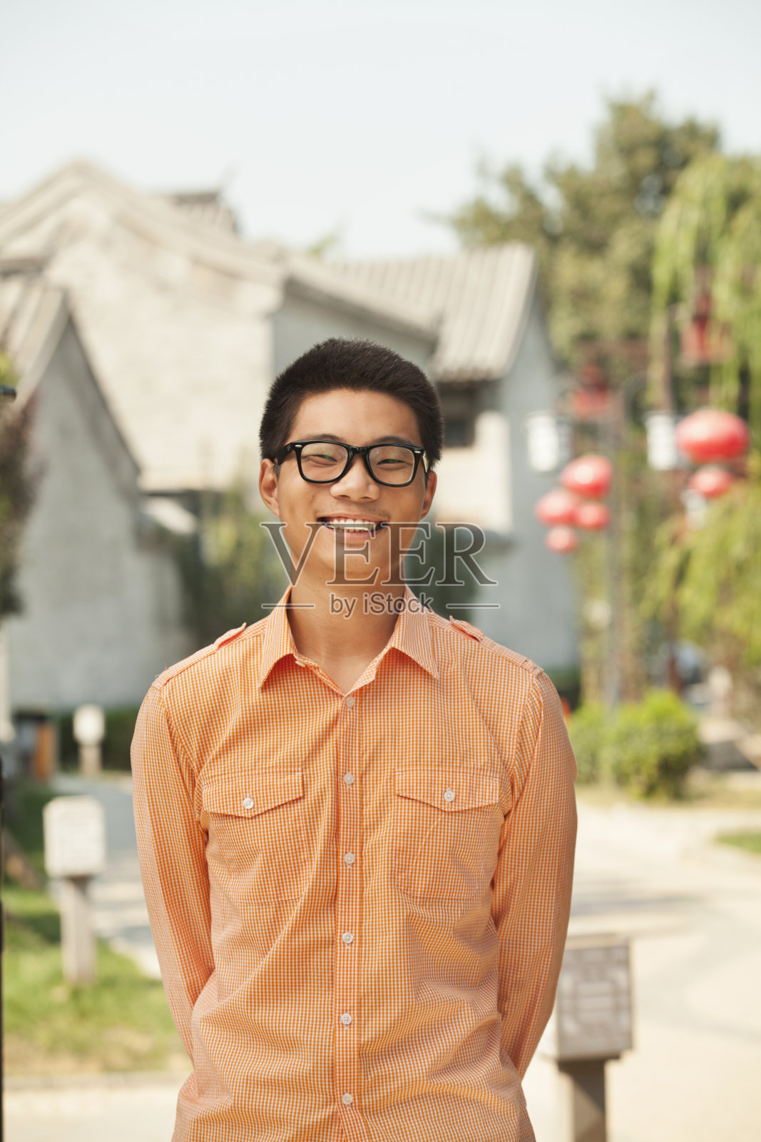 中国北京南锣鼓巷，一名戴眼镜的微笑青年照片摄影图片