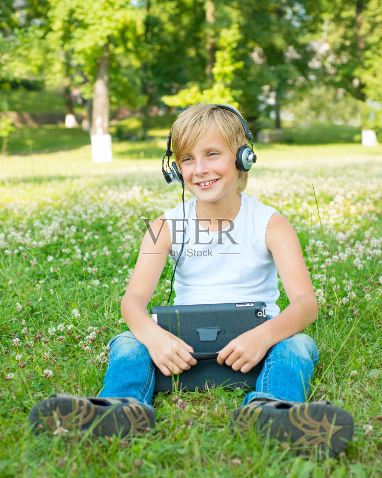 拿着平板电脑和耳机的男孩照片摄影图片