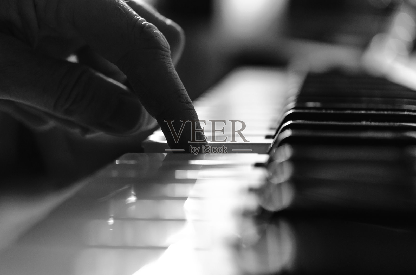 在黄昏用手指弹奏钢琴。照片摄影图片