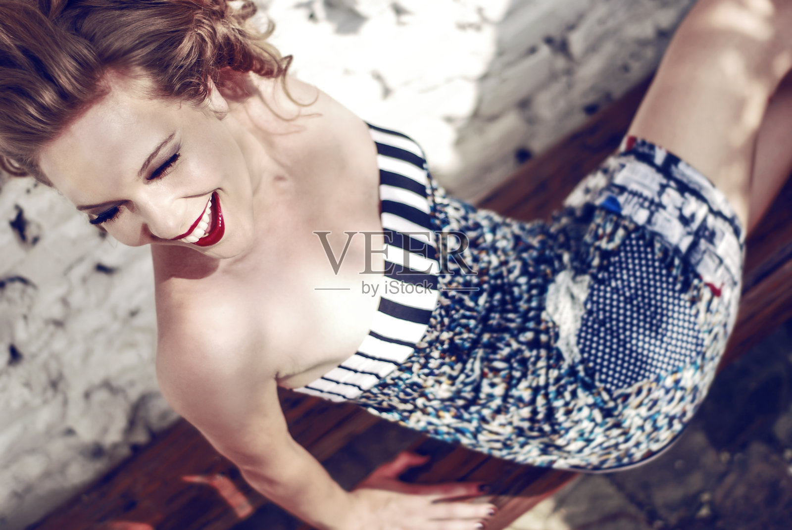 美丽的金发女孩坐着，面带微笑照片摄影图片