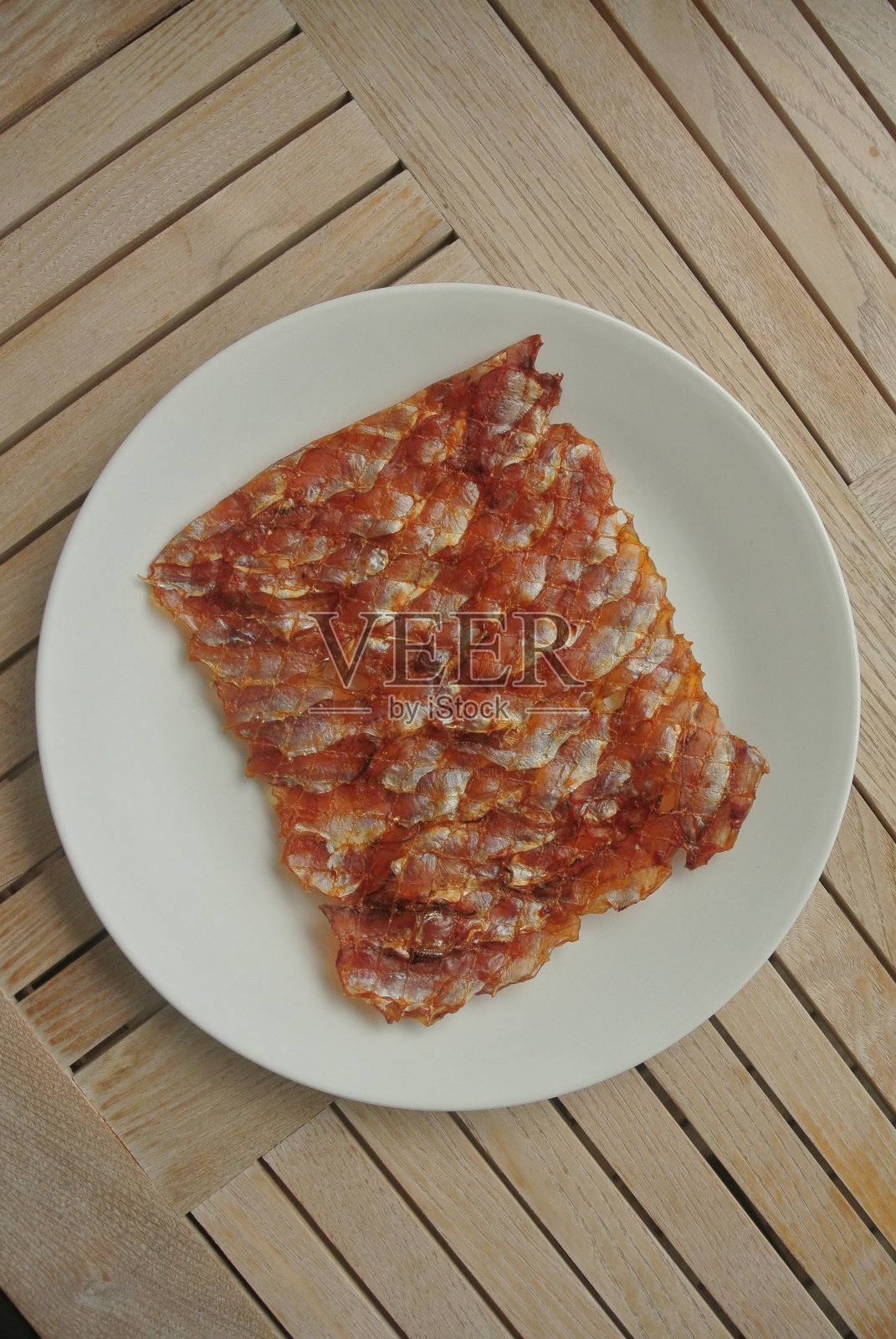 晒干的烤鱼片放在盘子里照片摄影图片