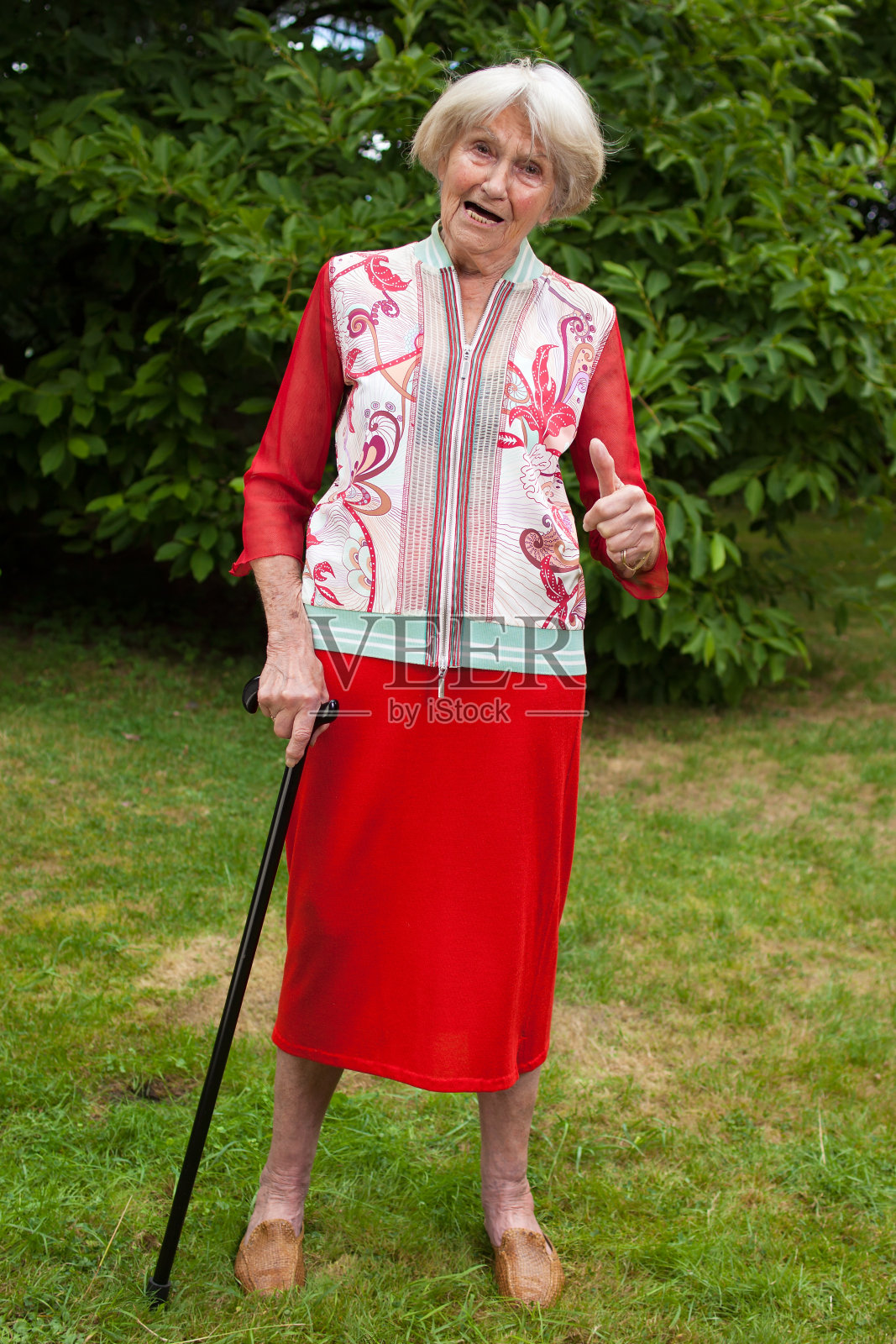 时髦的老妇人竖起大拇指。照片摄影图片