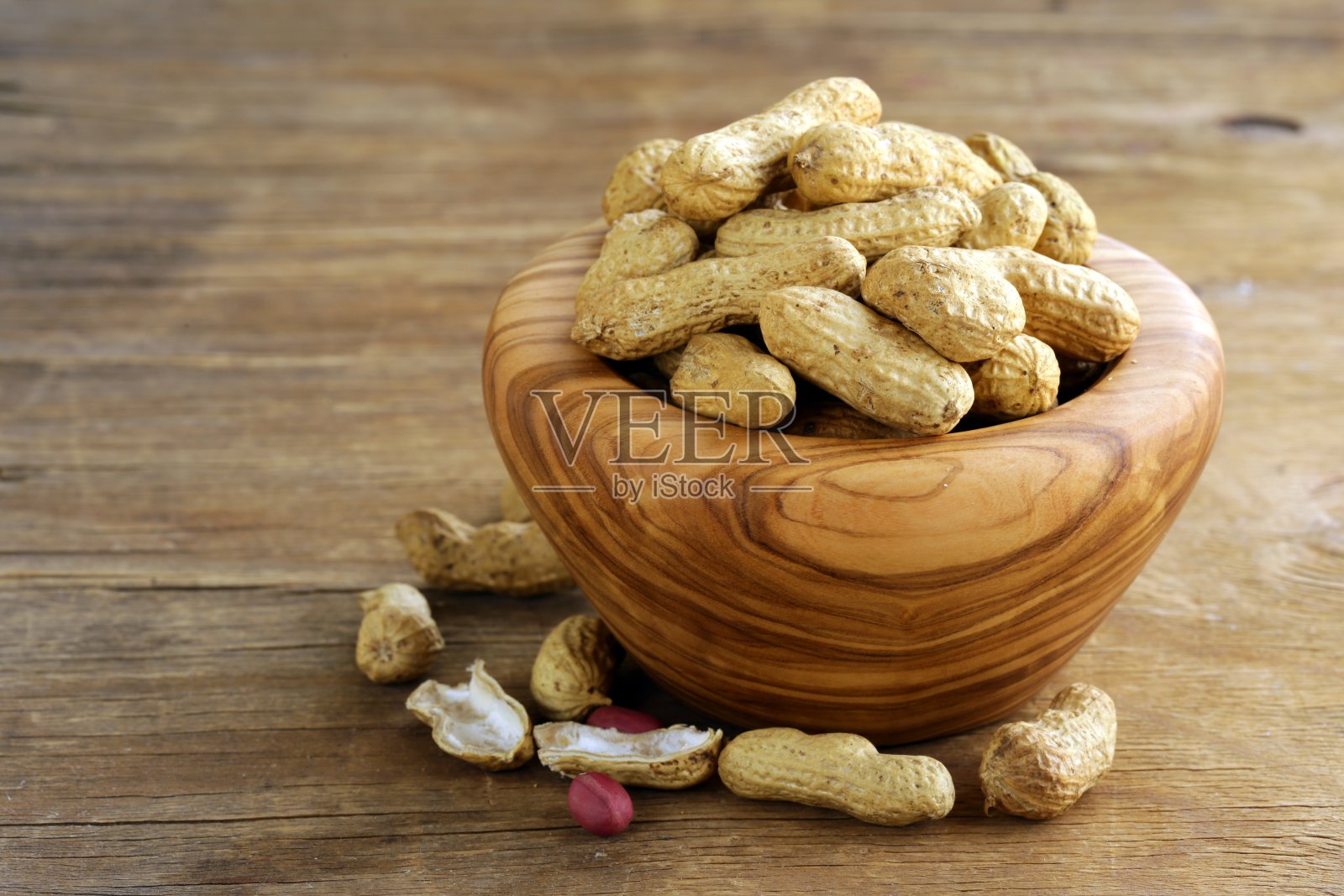 桌上的木碗里装着花生坚果照片摄影图片