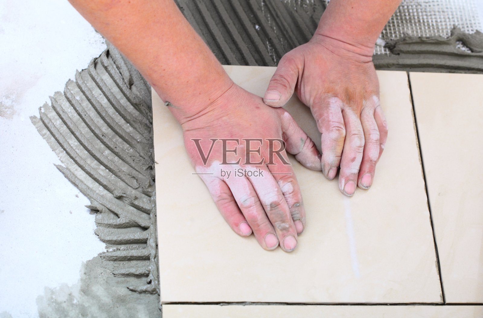 建筑工人正在家里铺瓷砖，贴瓷砖地板照片摄影图片