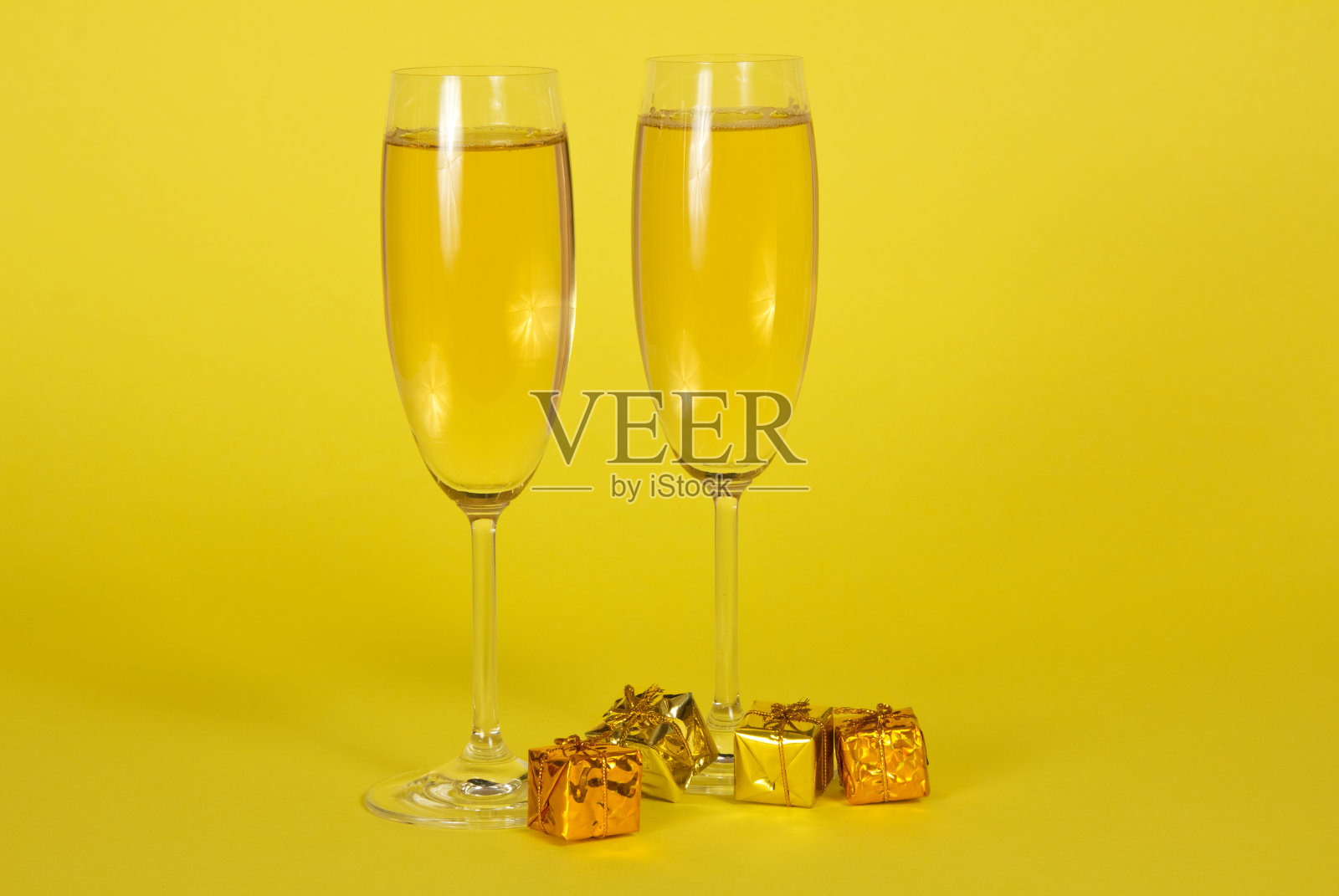 两个盛着香槟的酒杯和明亮的小礼品盒照片摄影图片
