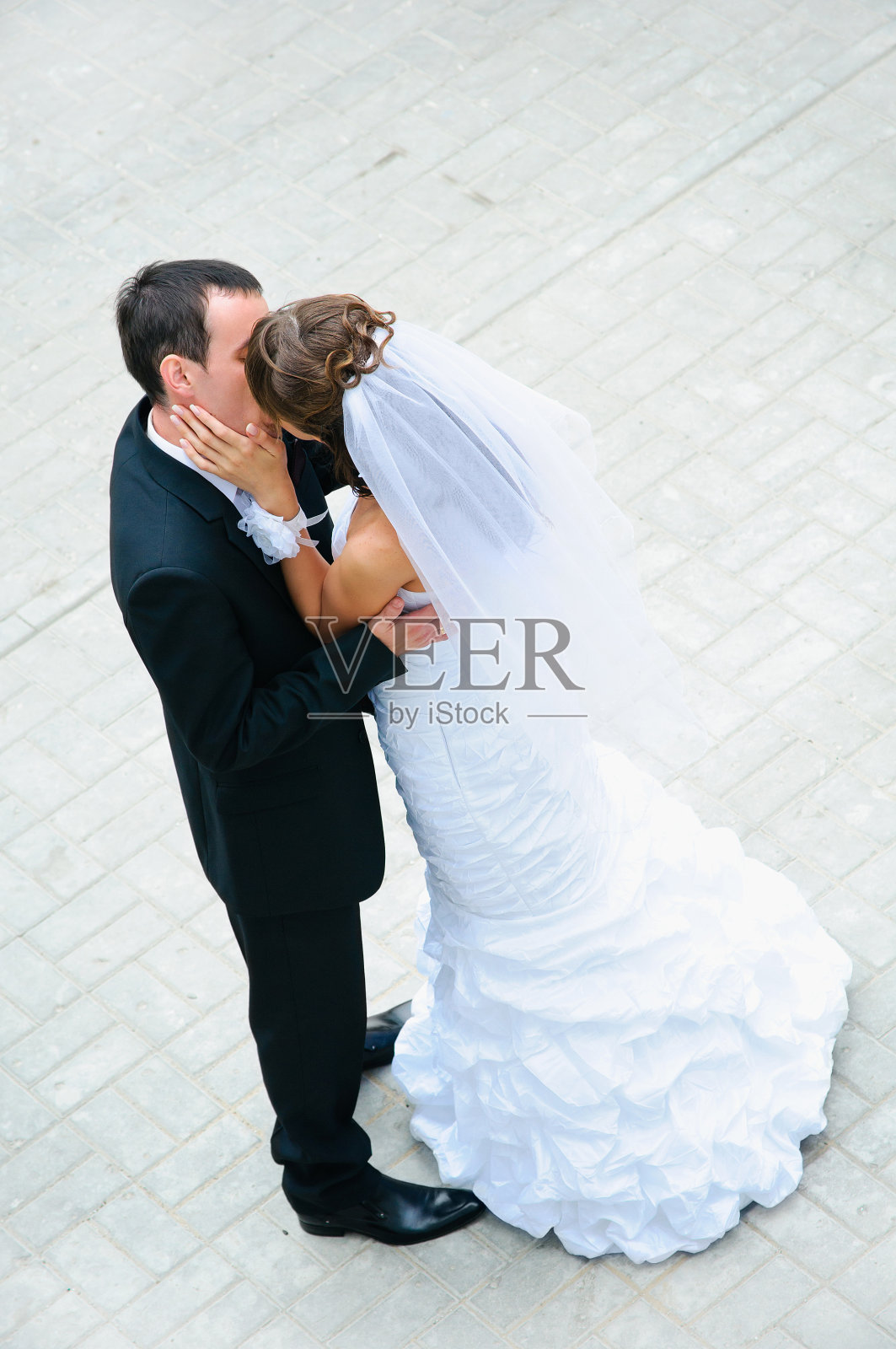 幸福的新婚夫妇站起来，亲吻和拥抱照片摄影图片